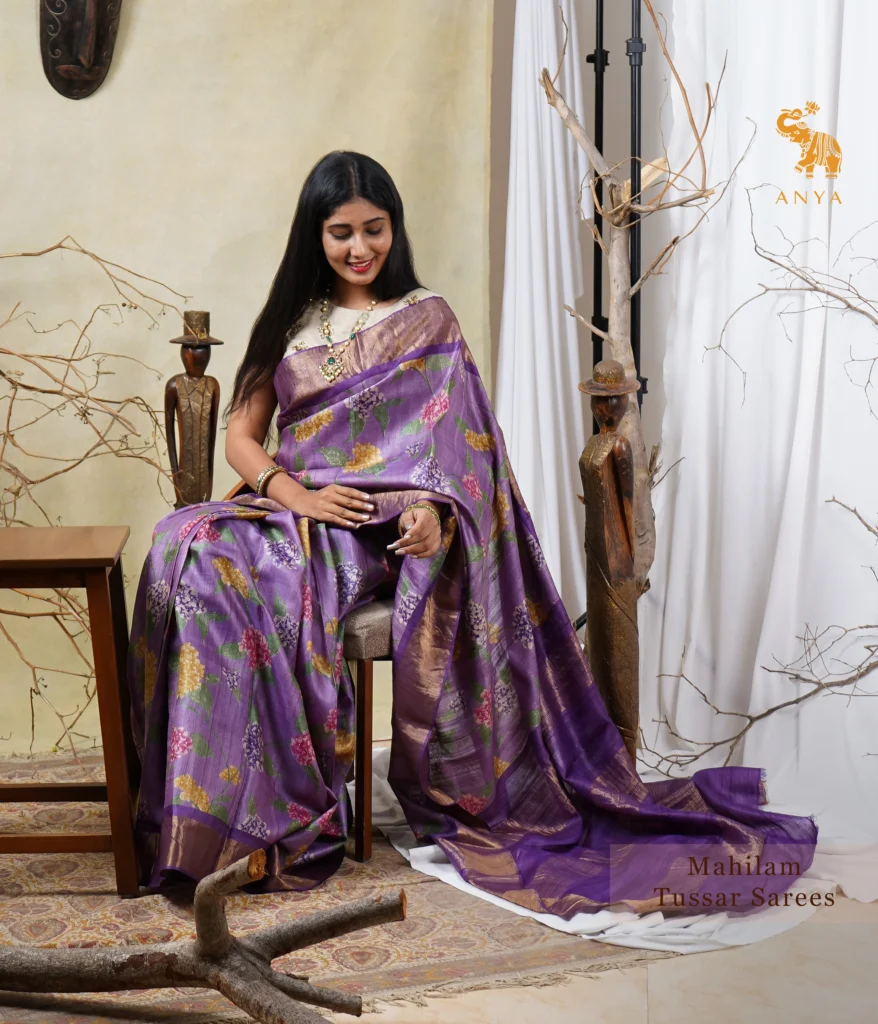 A delicate lavender Tusar silk saree featuring a contrasting violet border, offering a graceful and sophisticated look with its subtle sheen and intricate design, perfect for festive occasions and elegant events.