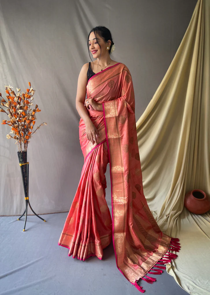 Latest Saree Designs 2025 Salmon pink saree made of Kasturi cotton, featuring a soft, textured fabric with a subtle sheen, perfect for elegant, traditional wear.