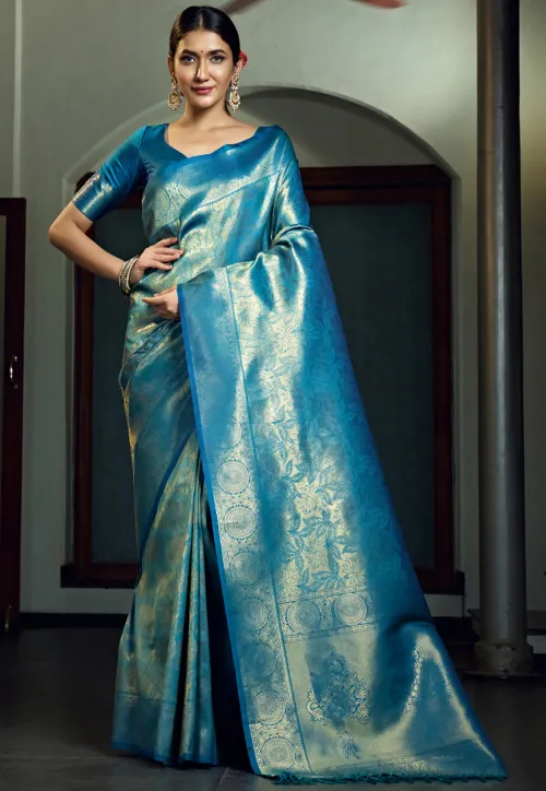 A vibrant blue Kanchipuram art silk saree featuring intricate gold zari work, with a contrasting border and traditional motifs, offering a blend of elegance and modern appeal.