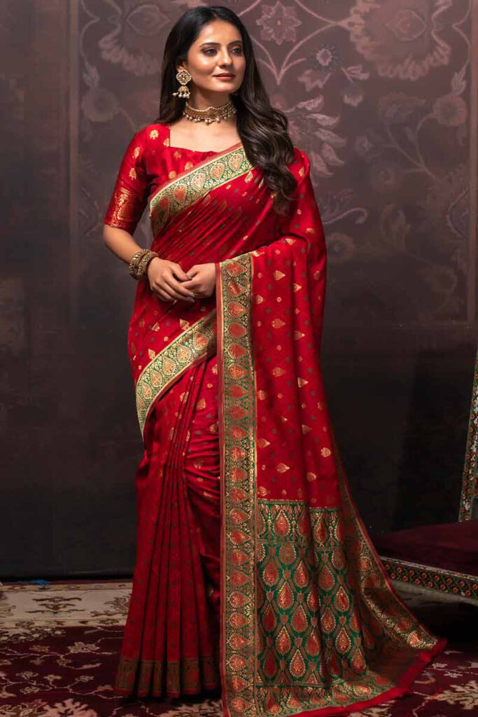 Red Banarasi silk saree with green antique zari border, featuring intricate craftsmanship and traditional elegance.